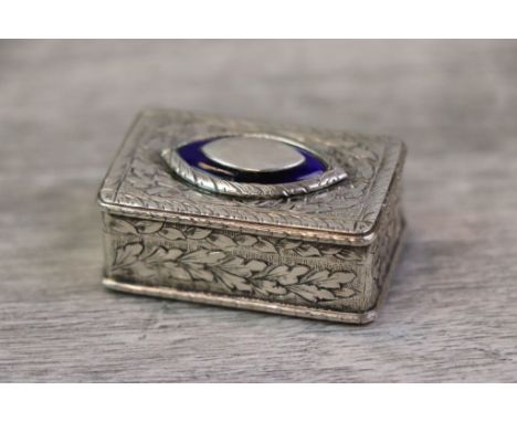 Enamelled white metal snuff box, the hinged lid with blue enamelled marquise 'eye' to centre, scroll engraved surround, folia