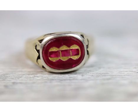 Synthetic ruby yellow metal signet ring, engraved gilt motif to synthetic ruby, tapered band, ring size K½, tests as gold 