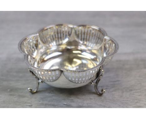 Early George V pierced silver bon bon dish of scalloped form raised on three scrolled ball finial feet, pattern in low relief