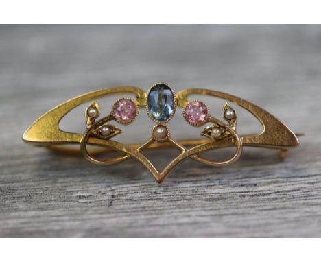 Art Nouveau tourmaline and seed pearl 15ct yellow gold brooch, the sinuous scrolling from set to centre with oval mixed cut b