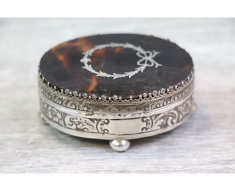 Edwardian tortoiseshell silver trinket box of oval form raised on four bun feet, the tortoiseshell hinged lid with wreath, ri