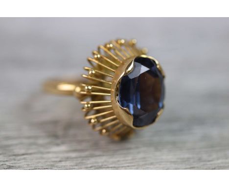 Synthetic colour change sapphire sunburst 18ct yellow gold ring, the central oval mixed cut stone measuring approximately 13m