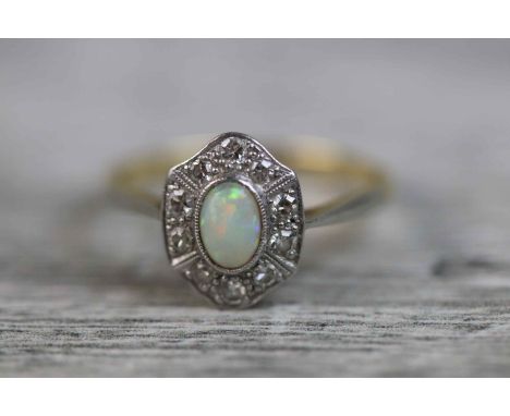 Opal and diamond 18ct yellow gold and platinum set cluster ring, the central oval cabochon cut precious white opal measuring 