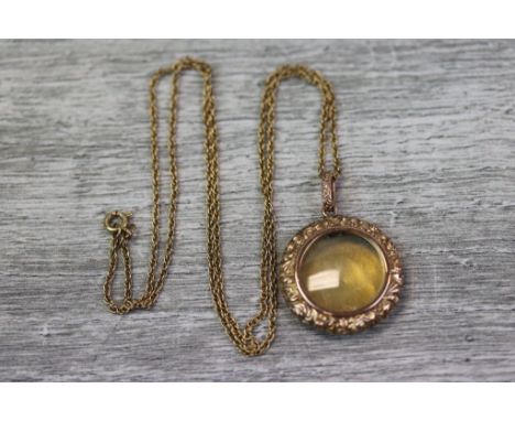 Victorian rose metal pendant of circular form, central glazed compartment with cast foliate scroll surround, engine turned de