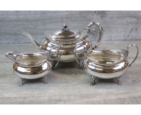 George V three piece silver tea service comprising teapot, sugar bowl and milk jug, of rounded form raised on four hoof feet,