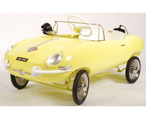 An incredible vintage 1960's Triang / Tri-ang made E-Type Jaguar child's pedal car. Steel body in yellow with white and chrom