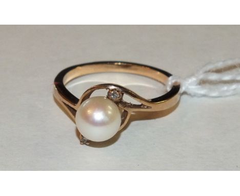 A gold cross-over ring set a cultured pearl between two diamond points, size M, 2.8g.