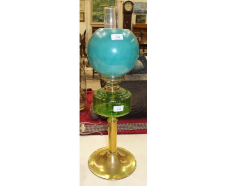 A late-19th/early-20th century oil lamp, the green glass reservoir on brass column and circular base, with green opaque glass