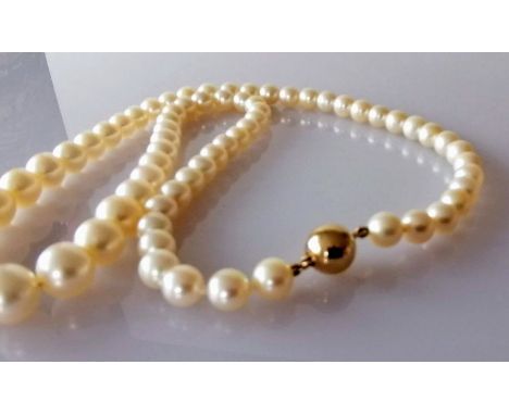 A mid-century single row of sixty-nine graduated Akoya cultured pearls measuring 6mm to 9.7mm with spherical gold clasp, stam