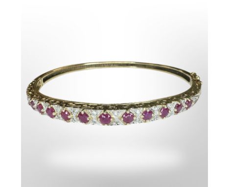 A 9ct gold ruby and diamond bangle, inner diameter 6cm.  CONDITION REPORT: 10.3g
