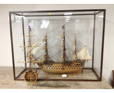 An impressive scale model of HMS Victory in glazed mahogany display case, measuring 113cm x 88cm x 43cm, together with a furt