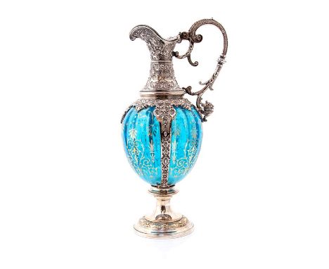 An ornate early 20th Century German WMF Claret Jug, silver plated detail showing embossed foliate and scroll decoration with 