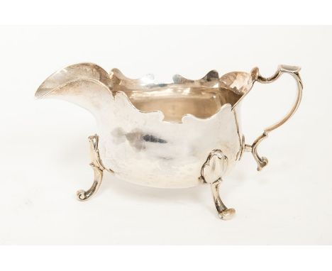 A George II Provincial silver plain squat sauceboat, cut card border above&nbsp;three scroll and trefoil&nbsp;feet, scroll ha