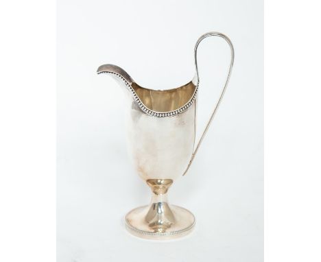 A George III plain silver helmet shaped cream jug, beaded rim on spreading circular foot with beaded border, C-scroll handle,