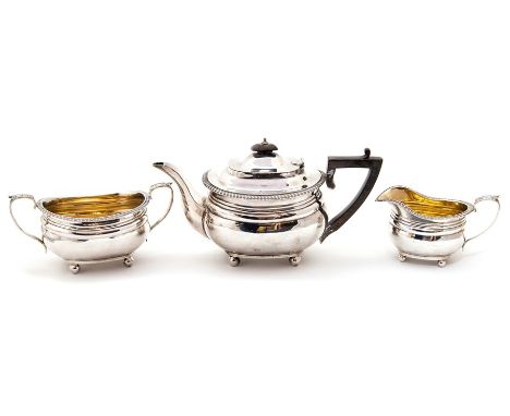 A George V silver three piece tea service comprising teapot, sugar bowl and milk jug, plain bodies with gadroon border, the t