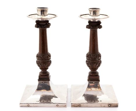 A pair of Arts and Crafts silver and oak candlesticks, A.E.Jones Birmingham 1914, approx 21.5cm high, damage to wooden scroll