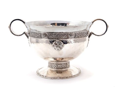 An Arts & Crafts silver Celtic Revival large two handled cup, hammered bowl with a band of intertwined Celtic motifs and roun