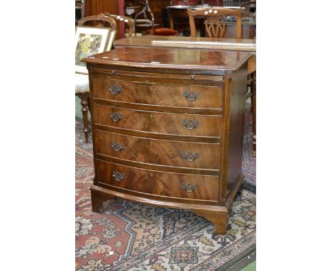 A reproduction serpentine fronted mahogany chest, moulded oversailing top above brush sliding tray, four long graduated cockb