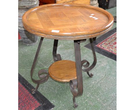 A wrought iron and light oak occasional table, parquetry dished top, scrolling S-form supports, moulded circular undertier, w