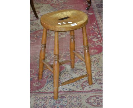 A light oak stool, round seat, turned legs and stretchers.