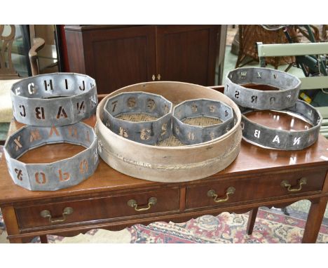 Vintage circular stencil sets, letters and numbers; a ratttan and bentwood riddle. (7)