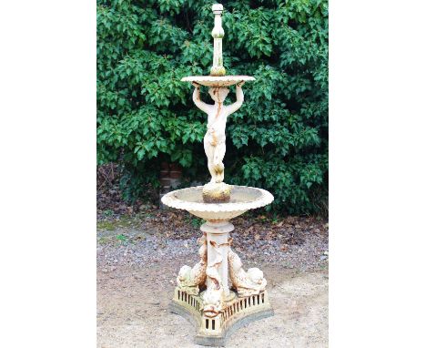 AN OLD CREAM PAINTED CAST IRON TWO TIER FOUNTAIN the upper bowl supported by a boy, the lower basin with octagonal support br