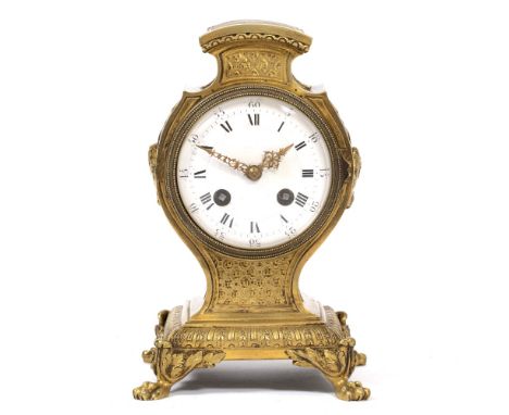 AN ORMOLU MANTLE CLOCK in the Louis VIX style, c.1900, the shaped case set with female profile masks to either side and all s