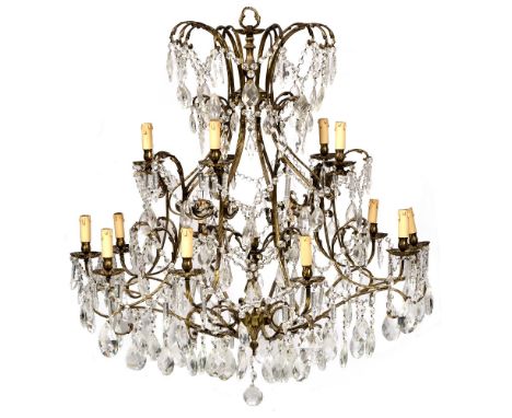 A LARGE GILT BRASS FIFTEEN LIGHT HANGING CHANDELIER OR ELECTROLIER  with scrolling branches and swags of faceted glass drops,