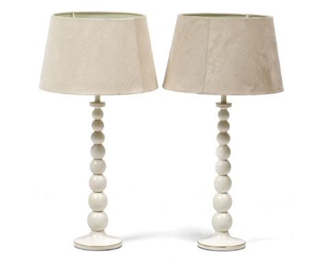 A PAIR OF WHITE PAINTED TABLE LAMPS of turned tapering bobbin form, with cream shades, 70cm in height overall (2)