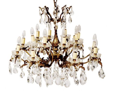 A GILT BRASS SIXTEEN LIGHT CHANDELIER OR ELECTROLIER  with cast acanthus leaf decorated scrolling branches and faceted glass 