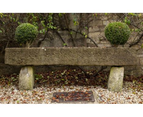 A LARGE RECTANGULAR CARVED STONE TROUGH with rough cut sides, 235cm wide x 47cm deep x 30cm high standing on stone supports