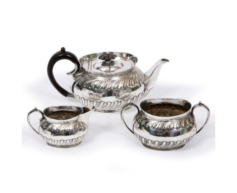 A LATE VICTORIAN SILVER MATCHED THREE PIECE TEA SET of ovoid form with gadrooned decoration to the body, the teapot with mark