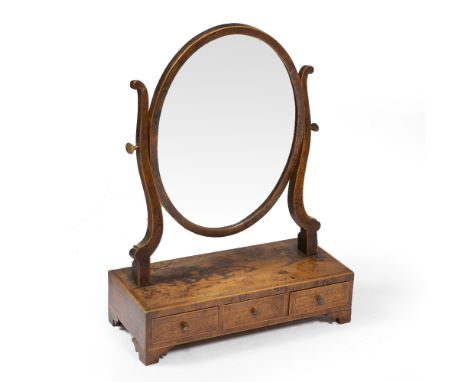 A REGENCY DRESSING TABLE MIRROR veneered in pollarded timber, the oval swing mirror on scrolling supports above a box base wi