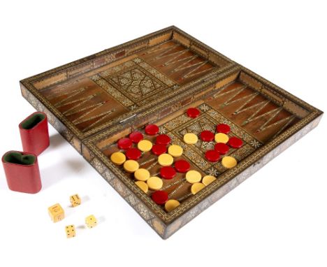 A MIDDLE EASTERN CHESS AND DRAUGHTS HINGED GAMES BOARD with parquetry inlay to include squares and stars within banded border