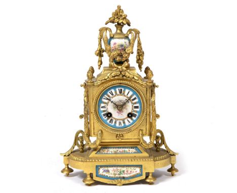 A CONTINENTAL GILT METAL CASED MANTLE CLOCK set with flower decorated porcelain mounts, the cased surmounted by an urn finial