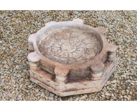 A CARVED INDIAN MARBLE BASIN OR STAND of octagonal form with central lotus flower decoration, 61cm wide x 19cm high 