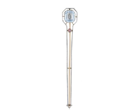 An Art Deco aquamarine brooch, circa 1920, the tapered brooch with a knifewire outline, set with a step-cut aquamarine and a 