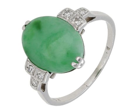 An Art Deco jade and diamond ring, the oval jadeite cabochon with three single-cut diamonds to either side, mounted in platin