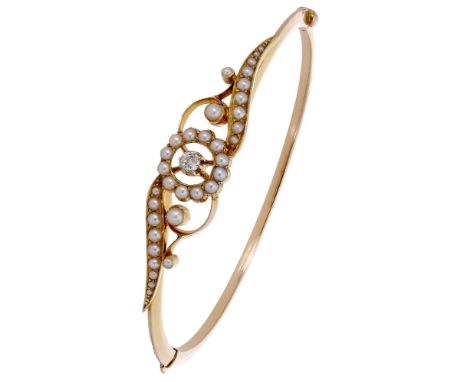 A seed pearl bangle, circa 1900, the frontispiece of openwork scroll design and set with seed pearls, with an old brilliant-c