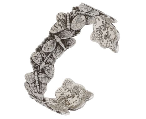 A silver bangle by Malcolm Appleby, designed as a series of overlapping butterflies, the underside with engraved cloud and sc