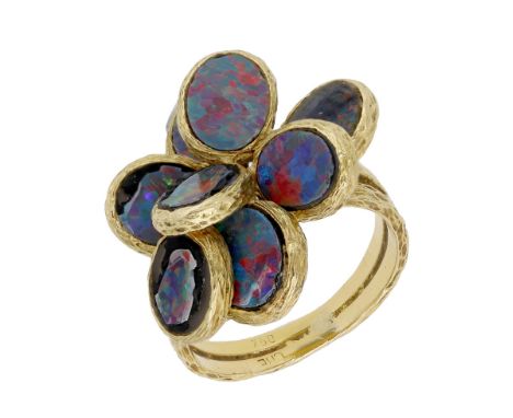 An 18ct gold opal doublet dress ring, 1972, of abstract flowerhead design, each of the textured petals set with an opal doubl