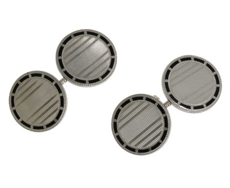 A pair of cufflinks, the circular plaques with linear decoration and black enamel borders, with chain connectors, stamped ‘14