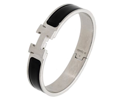 A ‘Clic H’ bracelet by Hermès, with black enamel shoulders, signed, inner diameter 5.5cm. £100-£150
