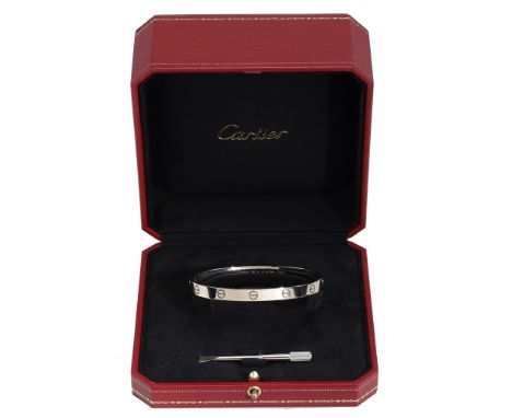 An 18ct white gold ‘Love’ bangle by Cartier, the polished bangle with screwhead motif throughout, signed ‘Cartier’, serial nu