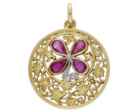 A ruby and diamond pendant, French, circa 1910, the circular pendant pierced and decorated with ivy and scrolling foliage, wi