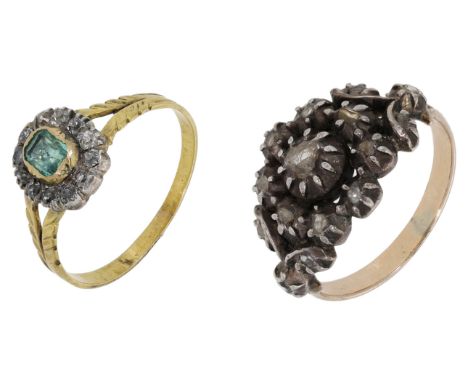 Two early 19th century rings, the first set with an emerald within a surround of old brilliant-cut diamonds, between bifurcat