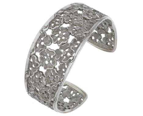 A silver bangle by Malcolm Appleby, the openwork cuff formed from overlapping flowerheads, with engraved linear decoration to
