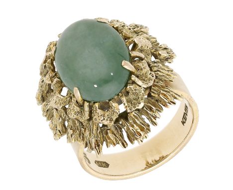A green hardstone dress ring, circa 1970, the cabochon claw-set to a textured abstract mount, stamped ‘14K’, ring size M - N.