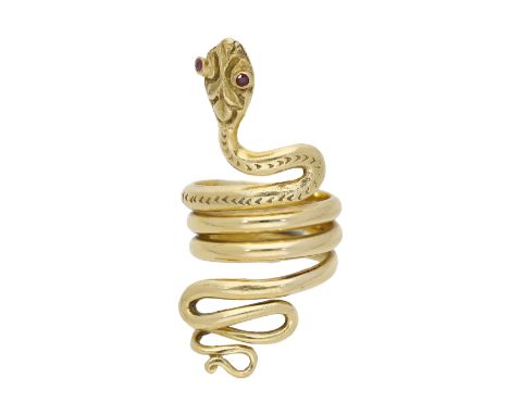A serpent ring, the coiled serpent with engraved scale pattern decoration and ruby gem-set eyes, stamped ‘750’, ring size K. 