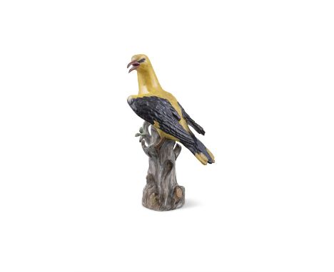 A 19TH CENTURY MEISSEN PAINTED PORCELAIN MODEL OF A GOLDEN ORIOLE,standing on a tree trunk with leafy branch, unglazed blue c